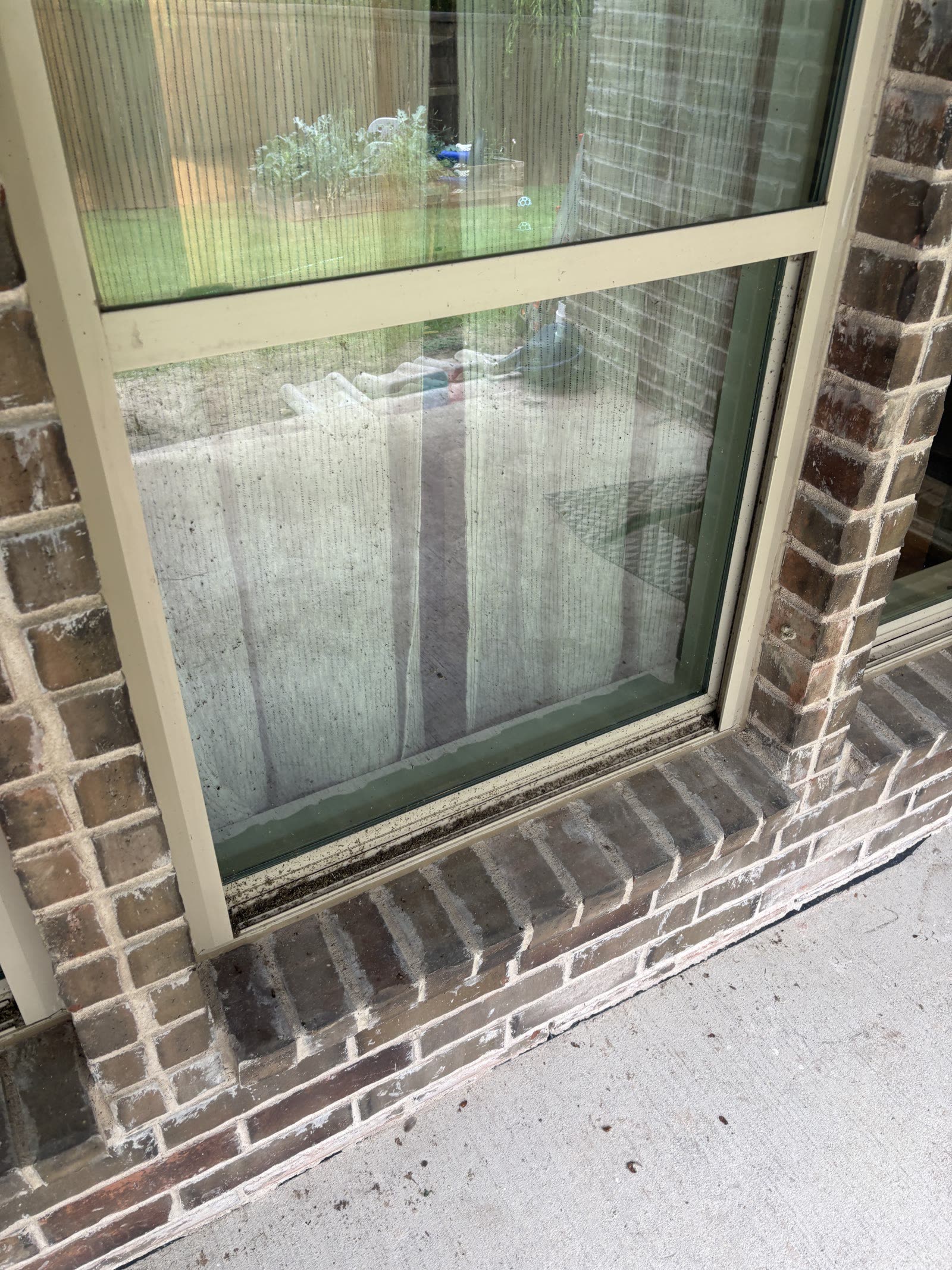 Residential window showing exterior dirt and water spotting before cleaning