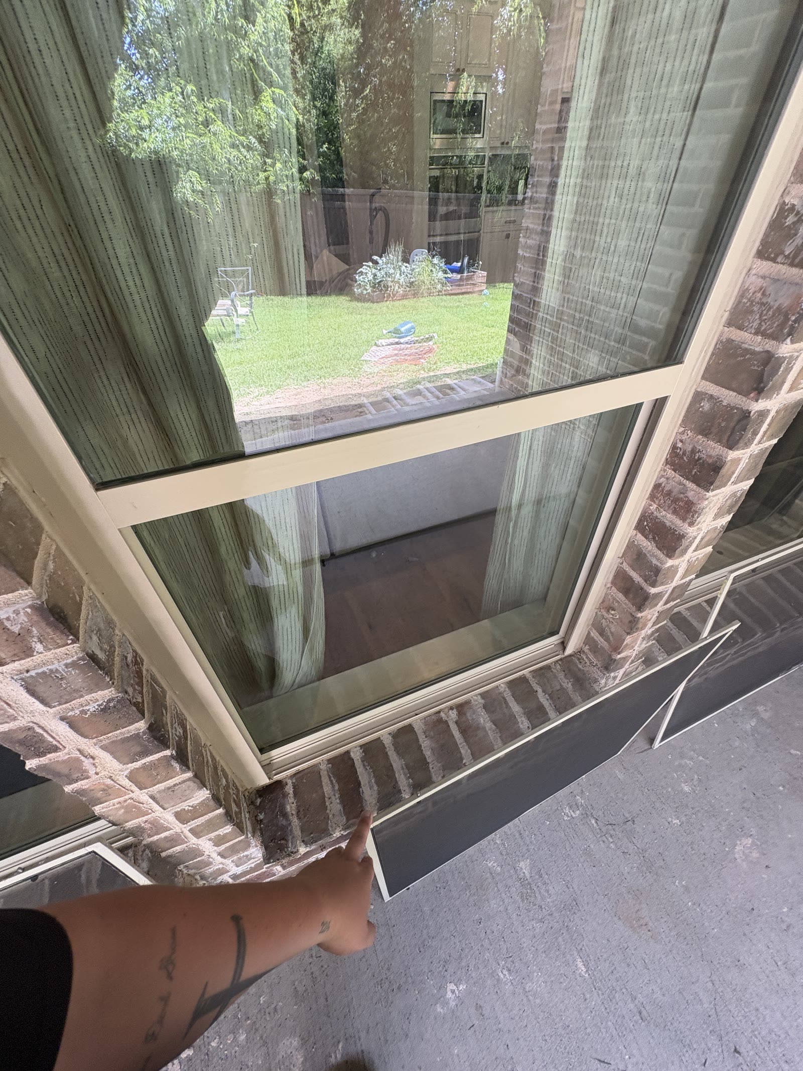 Large window pane on a brick home being cleaned by hand