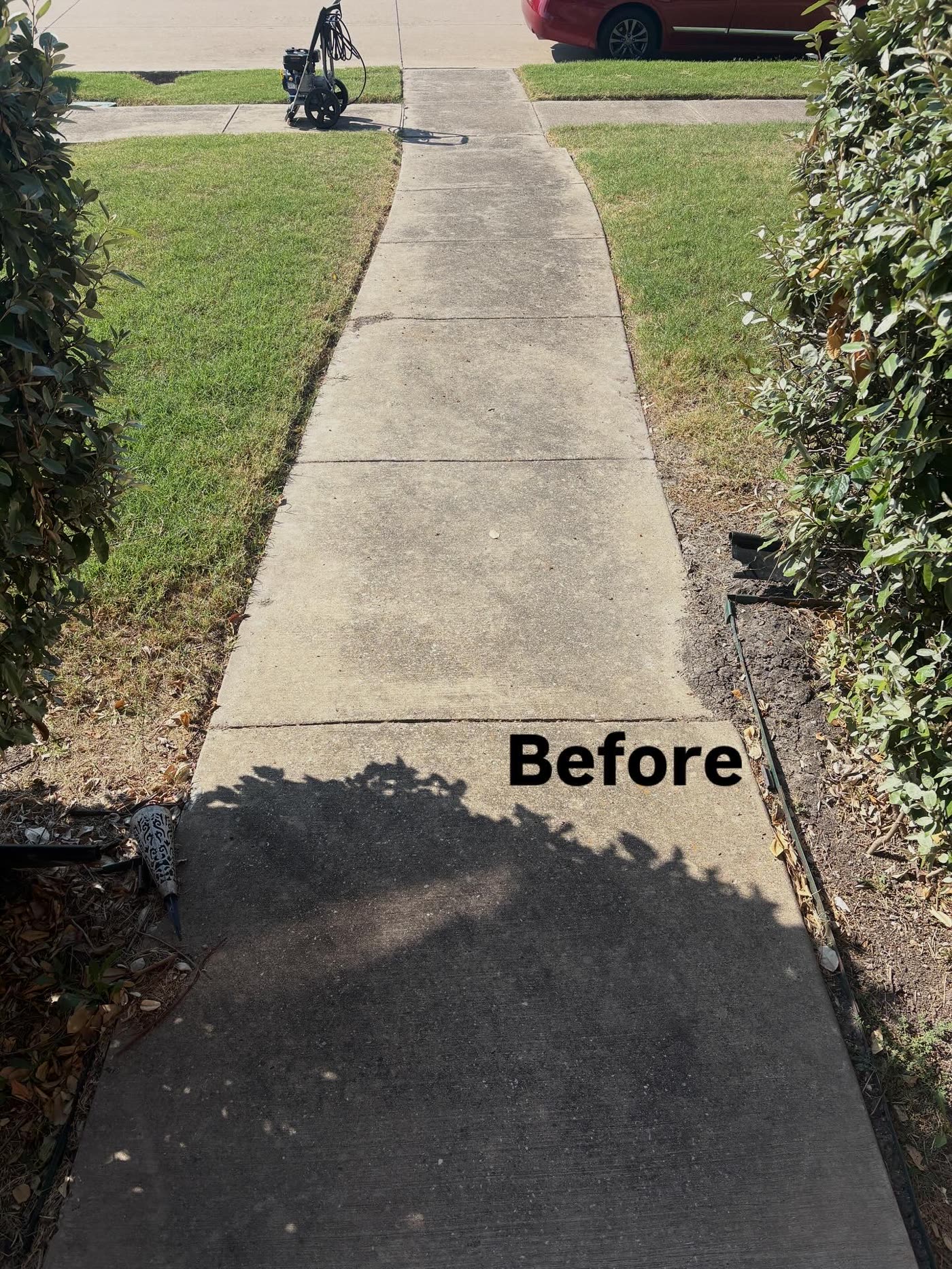 The same concrete sidewalk before washing, with dirt and dark staining