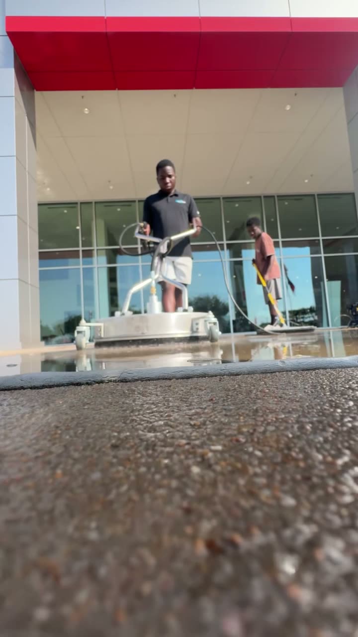 Concrete walkway outside a storefront being washed clean
