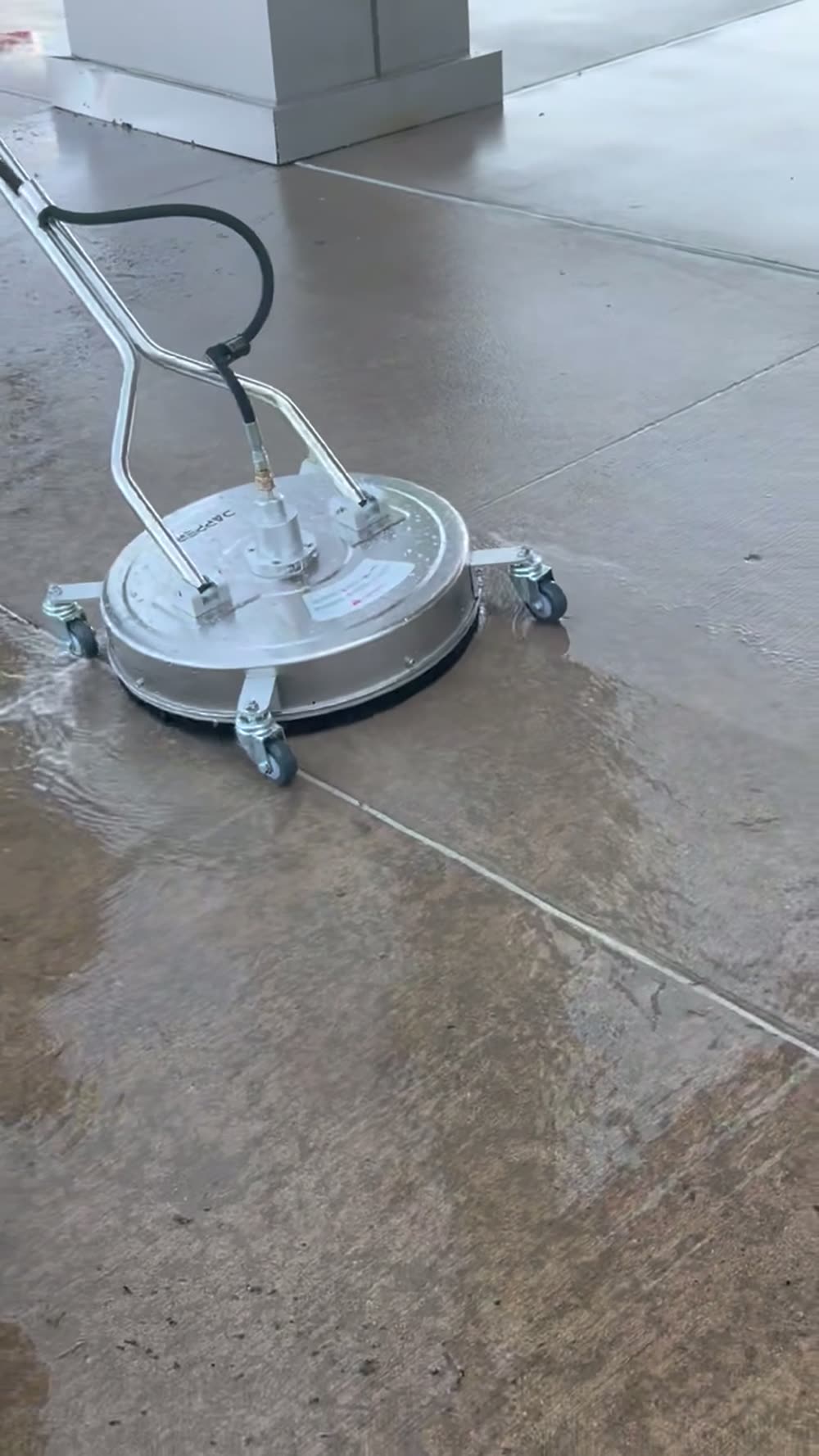 Surface cleaner washing a wide light concrete walkway