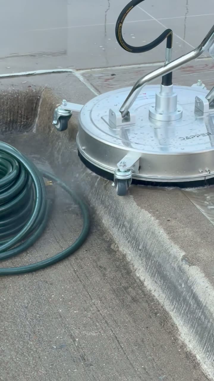 Close view of a surface cleaner washing a concrete patio