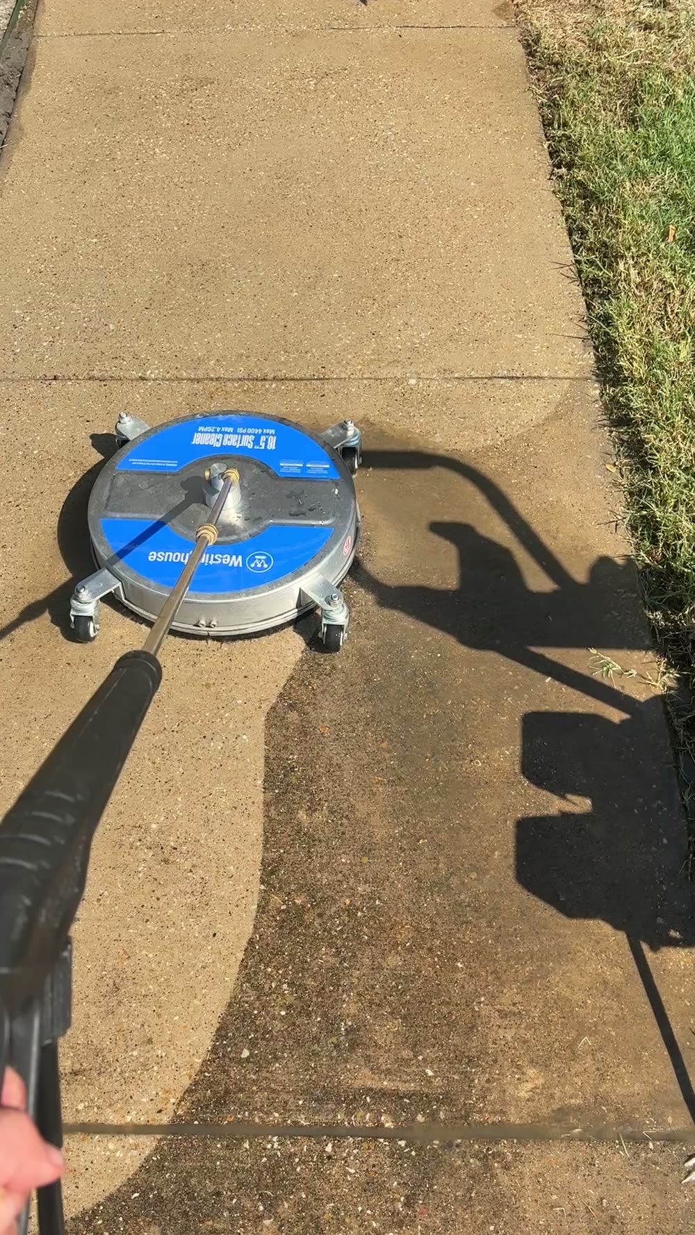 Surface cleaner partway down a residential sidewalk, with the cleaned section clearly lighter